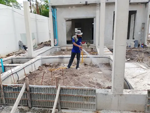 ช่างปฏิบัติงานระบบท่อกำจัดปลวกภายในอาคารระหว่างก่อสร้าง